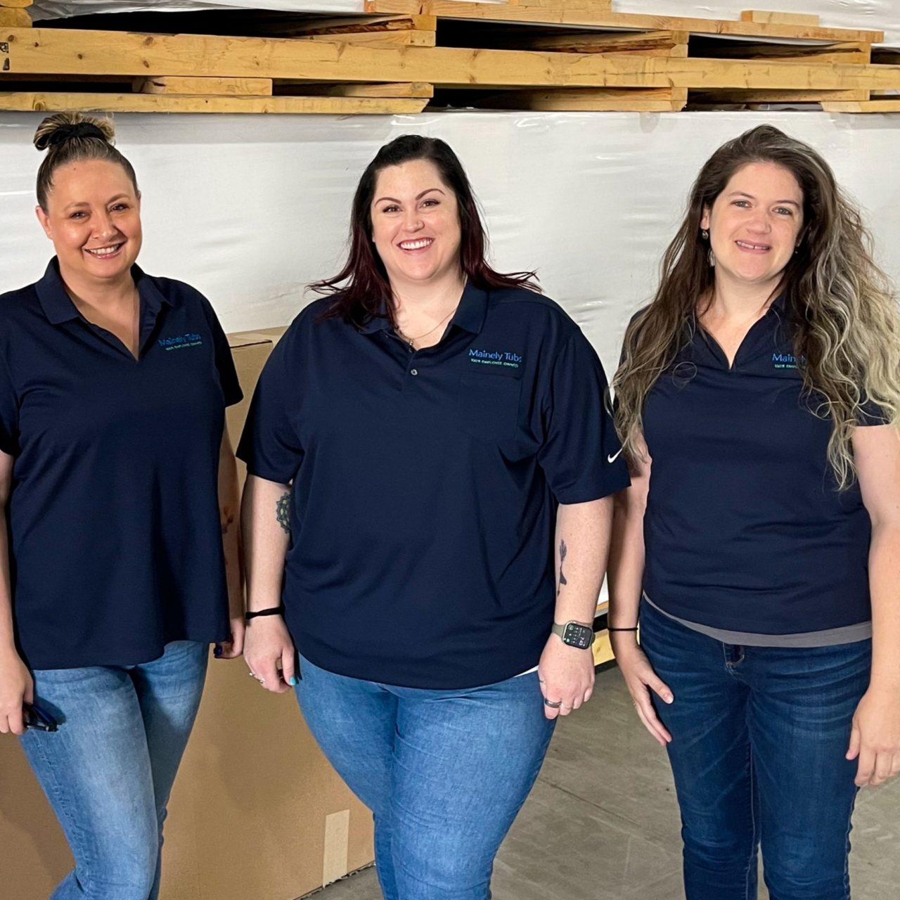 Photo of three women on service team standing in the warehouse.