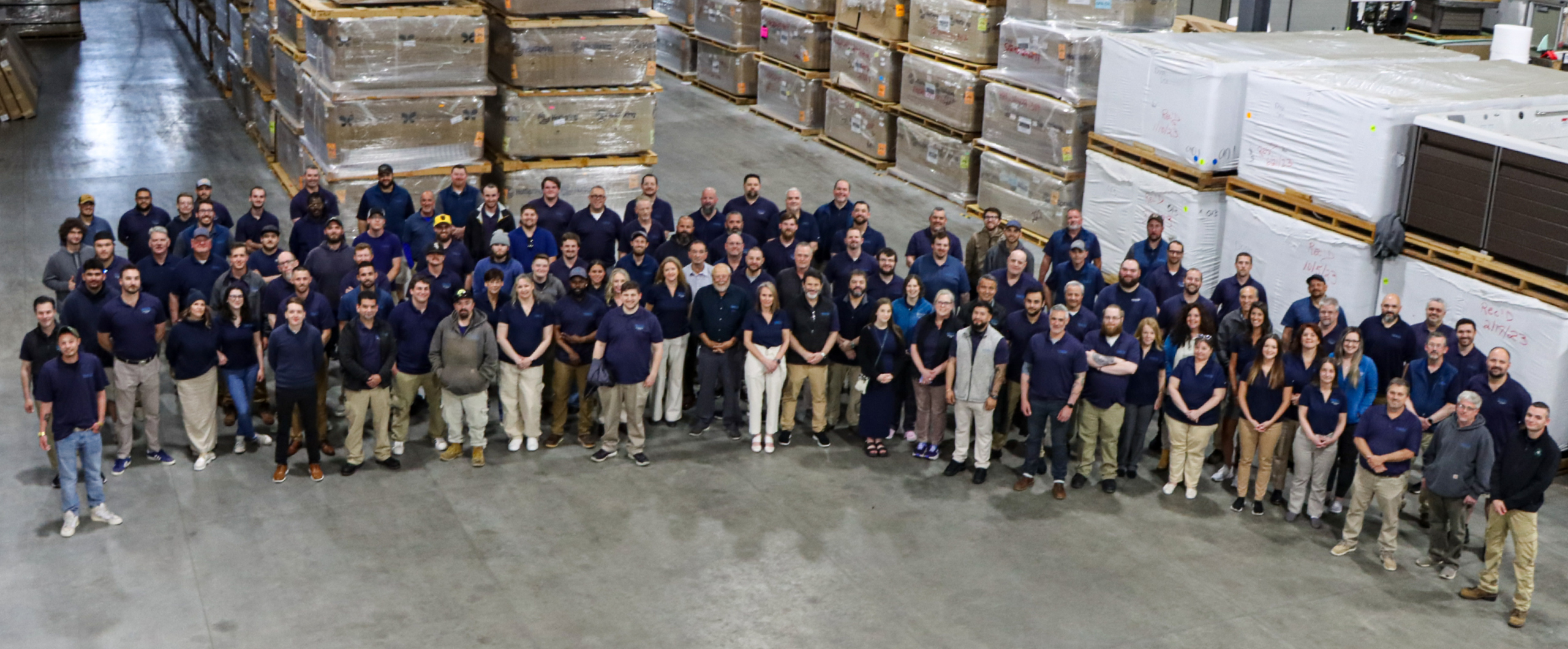 Team photo of the Mainely Tubs employees in the warehouse.