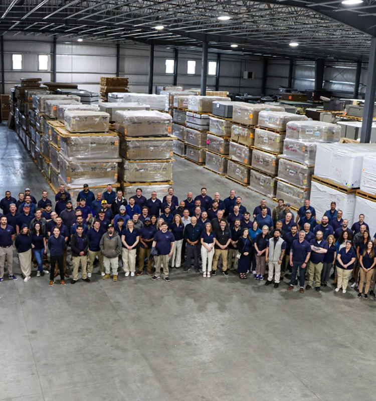 Team photo of Mainely Tubs employees in the warehouse.